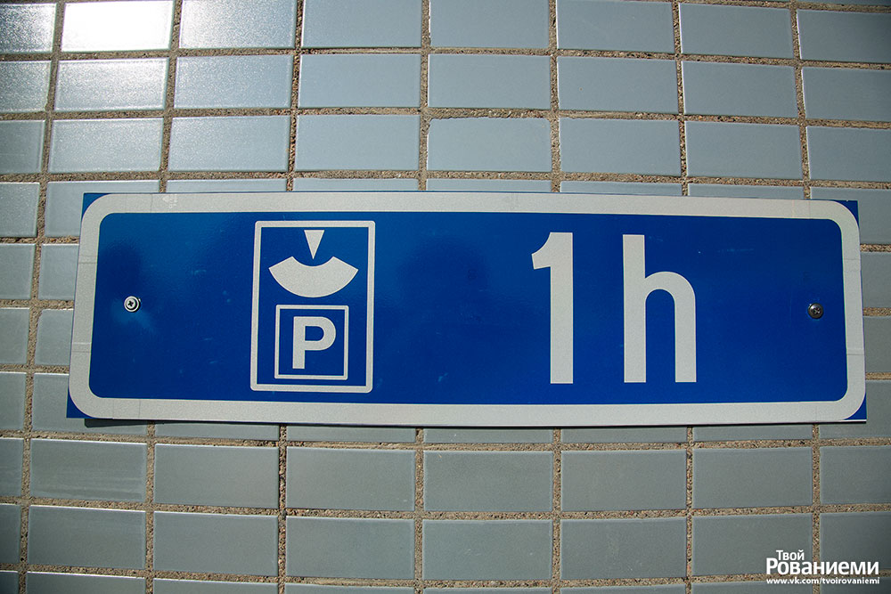 Знак бесплатной парковки на час с парковочными часами.